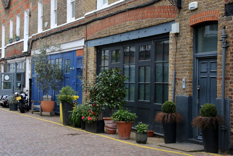 A close-up view of a brick building on Newton Street, featuring a weathered street sign with faded blue lettering mounted on the brick wall. The sign reads 'NEWTON STREET W.C. 2' and is surrounded by 